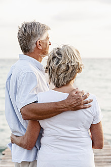 Spanien, Seniorpaar am Meer stehend - JKF000010