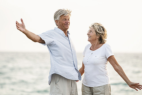 Spain, Senior couple having fun at the sea - JKF000011