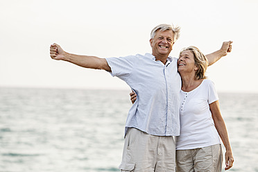 Spain, Senior couple having fun at the sea - JKF000012