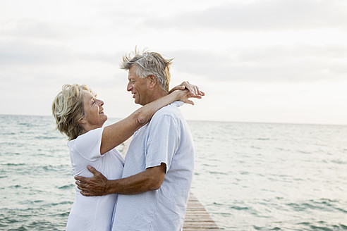 Spain, Senior couple embracing at the sea - JKF000015