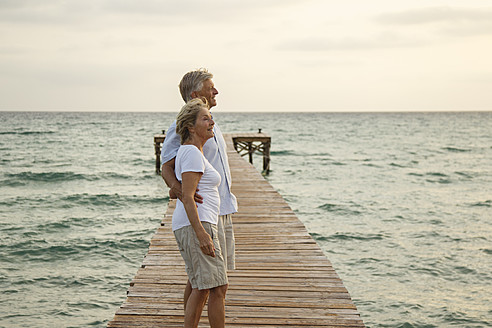 Spain, Senior couple standing on jetty at the sea - JKF000024