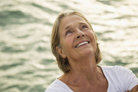 Spanien, Seniorin am Meer, lächelnd, lizenzfreies Stockfoto