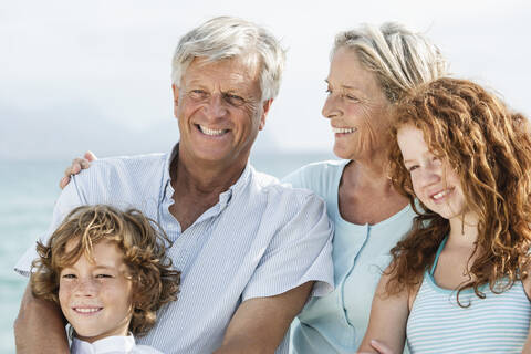 Spain, Grandparents with grandchildren at the sea, smiling, portrait stock photo