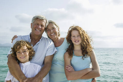 Spain, Grandparents with grandchildren at the sea, smiling, portrait stock photo