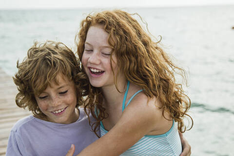 Spain, Girl and boy at the sea, smiling stock photo