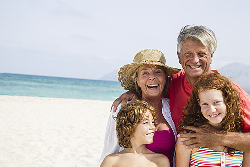 Spanien, Großeltern mit Enkelkindern haben Spaß am Strand, lächelnd - JKF000087