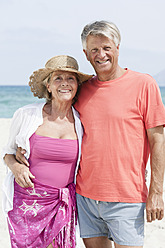 Spain, Senior couple standing at beach, smiling, portrait - JKF000111