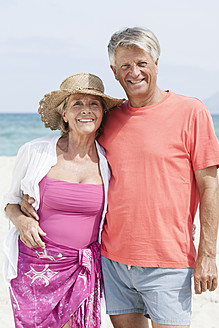 Spanien, Seniorpaar am Strand stehend, lächelnd, Porträt - JKF000111
