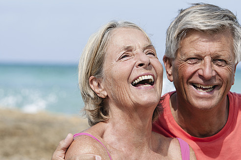 Spain, Senior couple at beach, smiling - JKF000119