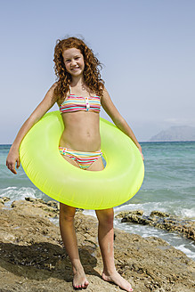 Spanien, Mädchen mit Schwimmring am Strand, lächelnd - JKF000135