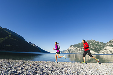 Italien, Mittleres erwachsenes Paar beim Joggen am Gardasee - MIRF000511