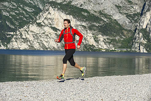 Italien, Mittlerer Erwachsener Mann beim Joggen am Gardasee - MIRF000516