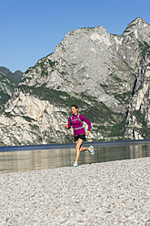 Italien, Mittlere erwachsene Frau beim Joggen am Gardasee - MIRF000519