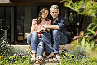 Germany, Berlin, Mature couple relaxing on terrace, smiling, portrait - SKF001103