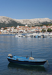 Kroatien, Boot im adriatischen Meer auf der Insel Krk mit der Stadt Baska im Hintergrund - WWF002541