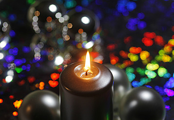 Kerzenlicht vor leuchtendem bunten Hintergrund - JTF000234