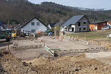 Deutschland, Rheinland-Pfalz, Hausbau, Erdarbeiten, Verlegung von Rohren vor dem Gießen des Betons für das Fundament - CSF016002