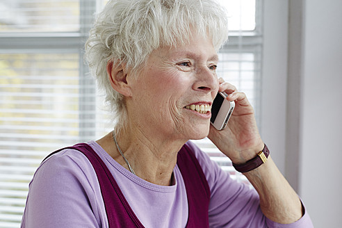 Deutschland, Düsseldorf, Ältere Frau telefoniert mit Handy, Nahaufnahme - STKF000081