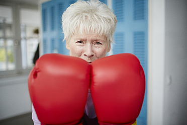 Germany, Duesseldorf, Portrait of senior woman with boxing glove - STKF000096