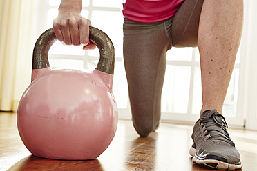 Deutschland, Düsseldorf, Ältere Frau trainiert mit Kettlebell - STKF000107