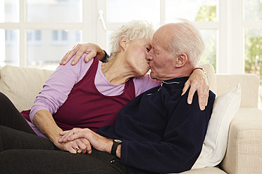 Germany, Duesseldorf, Senior couple kissing and relaxing at home - STKF000180