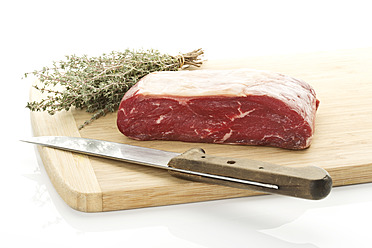Raw beef. garden thyme and knife on chopping board, close-up - MAEF005374