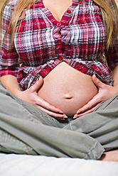 USA, Texas, Pregnant young woman holding stomach - ABAF000499