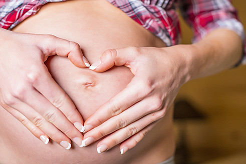 USA, Texas, Heart shape with hands over pregnant belly - ABAF000502