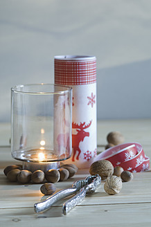 Nutcracker with walnut, hazelnut and candle on table, close up - ASF004703