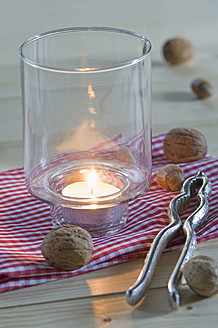 Nutcracker with walnut, hazelnut and candle on table, close up - ASF004704