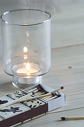Matches with Christmas motif and candle on table, close up - ASF004705