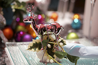 Christmas decoration with glass reindeer on dinner table, close up - HOHF000011