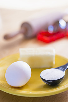 Zutaten für Weihnachtsplätzchen, Butter, Mehl und Ei auf einem Teller - ABAF000557