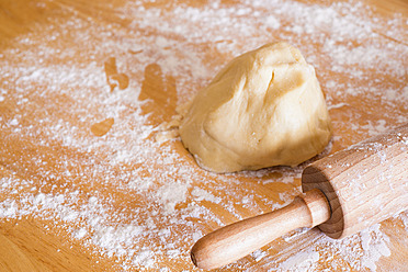 Chunk of dough with rolling pin and flour on kitchen table - ABAF000563