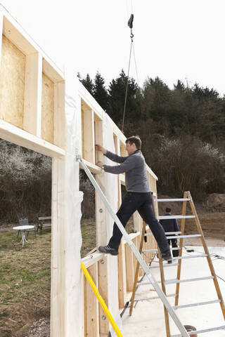 Europa, Deutschland, Rheinland Pfalz, Männer bei der Montage und Befestigung von Holzwänden eines Fertighauses, lizenzfreies Stockfoto