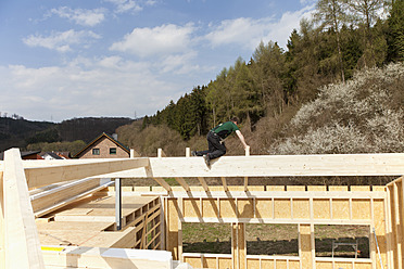Europa, Deutschland, Rheinland Pfalz, Mann bei der Montage und Befestigung von Holzwänden eines Fertighauses - CSF016066