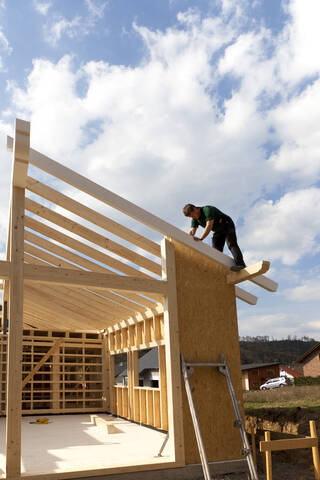 Europa, Deutschland, Rheinland Pfalz, Mann bei der Montage und Befestigung von Holzwänden eines Fertighauses, lizenzfreies Stockfoto