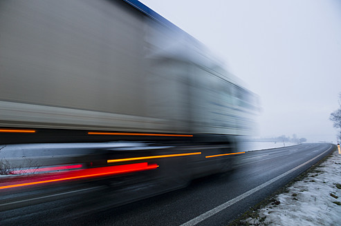 Österreich, Lastwagen auf der Landstraße im Winter - EJWF000165