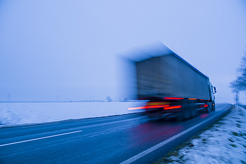 Österreich, Lastwagen auf der Landstraße im Winter - EJWF000164