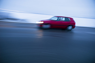 Österreich, Auto fährt auf Landstraße im Winter - EJWF000160