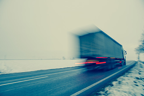 Österreich, Lastwagen auf der Landstraße im Winter - EJWF000159