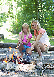 Austria, Friends preparing barbecue on camp fire - WWF002725