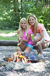 Austria, Friends preparing barbecue on camp fire - WWF002726