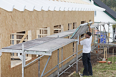 Europa, Deutschland, Rheinland-Pfalz, Junger Mann beim Zusammenbau eines Gerüsts - CSF016074