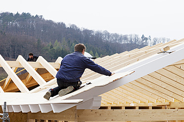 Europa, Deutschland, Rheinland Pfalz, Arbeiter decken Dach auf Haus - CSF016088