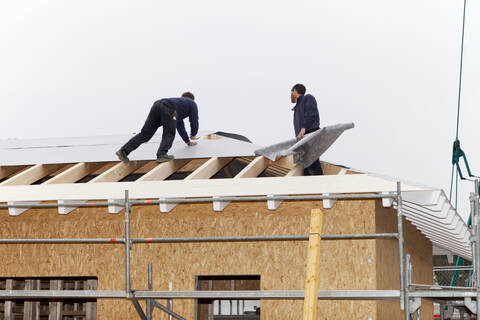 Europa, Deutschland, Rheinland Pfalz, Arbeiter decken Dach auf Haus, lizenzfreies Stockfoto