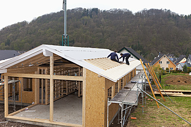 Europa, Deutschland, Rheinland Pfalz, Arbeiter decken Dach auf Haus - CSF016099