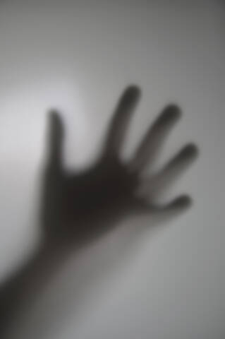 Menschliche Hand hinter Glasscheibe, Nahaufnahme, lizenzfreies Stockfoto