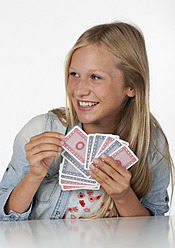 Teenage girl playing cards, smiling - WWF002473