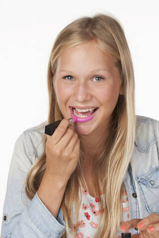 Teenager-Mädchen trägt rosa Lippenstift auf, Nahaufnahme, lizenzfreies Stockfoto